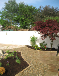 Sandstone patios, stone walkways, and stone edged planting beds